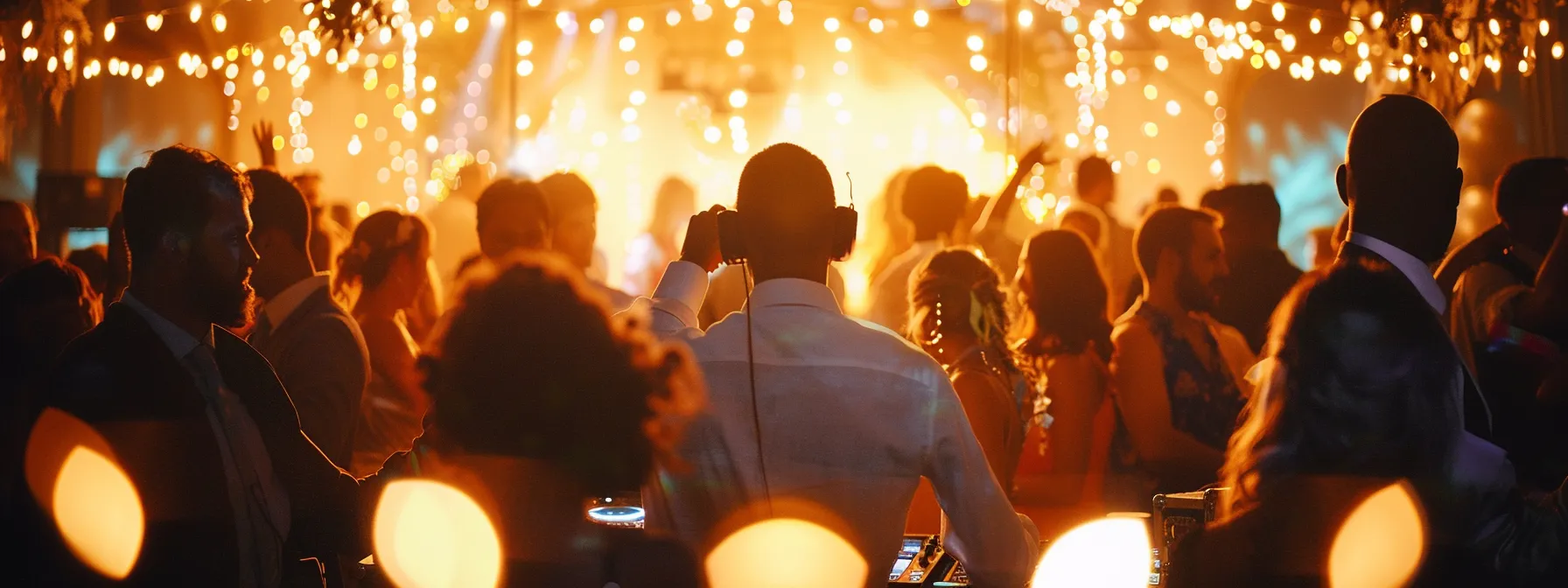 a vibrant wedding reception scene features a skilled dj immersed in a joyous atmosphere, expertly blending diverse music genres while guests dance in celebration under warm, ambient lighting.