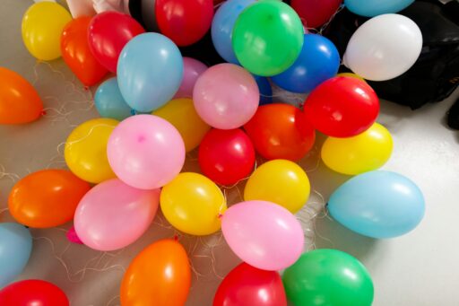 Bright balloons in many colours scattered across a floor.