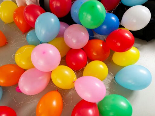 Bright balloons in many colours scattered across a floor.