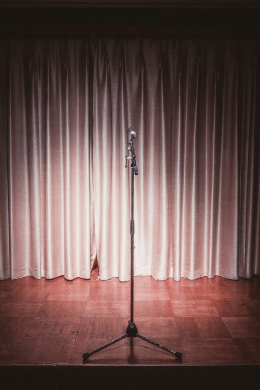 A microphone on a stand in front of a curtain