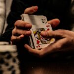 Person holding the king of spades playing card