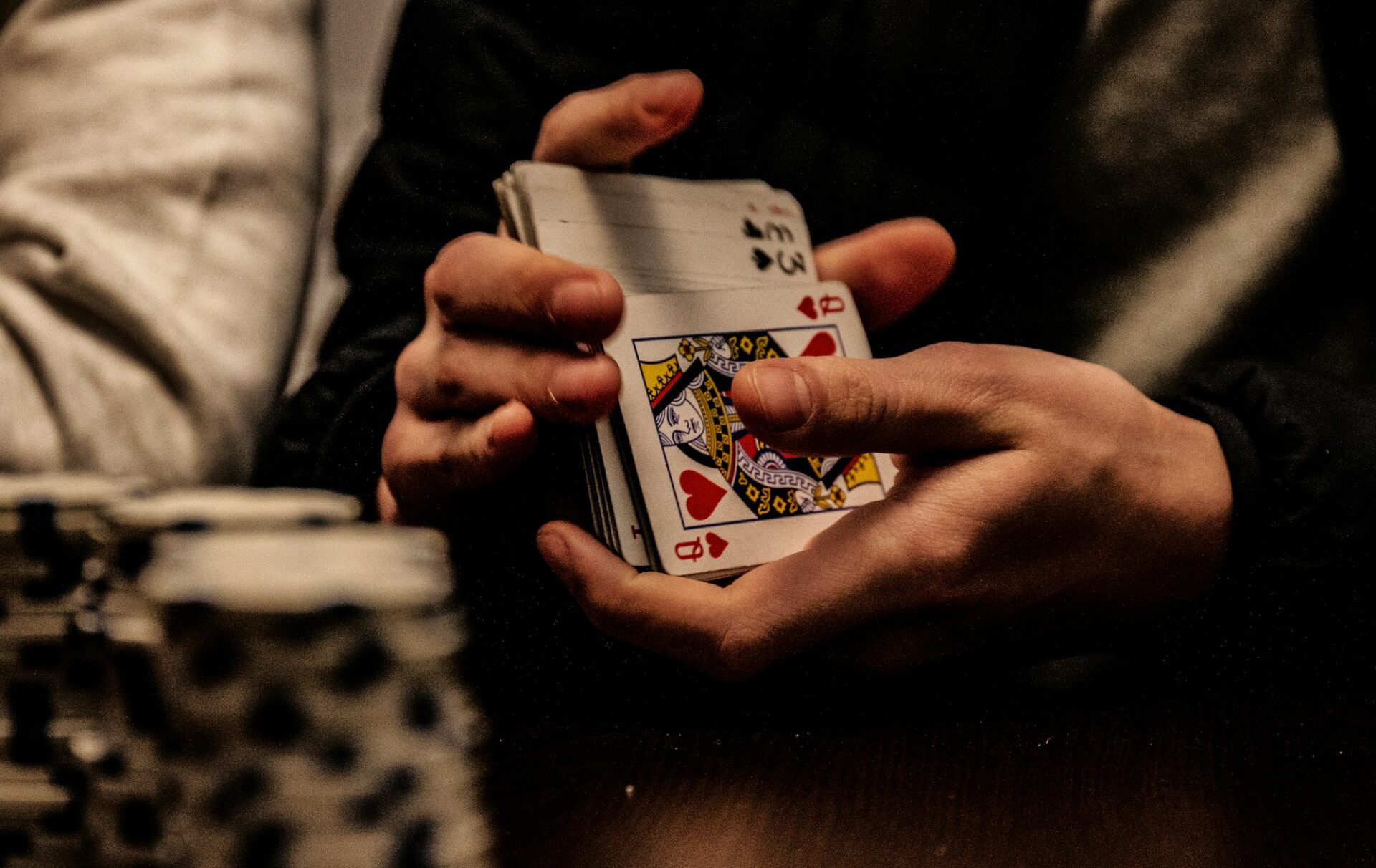 Person holding the king of spades playing card