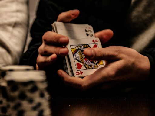 Person holding the king of spades playing card
