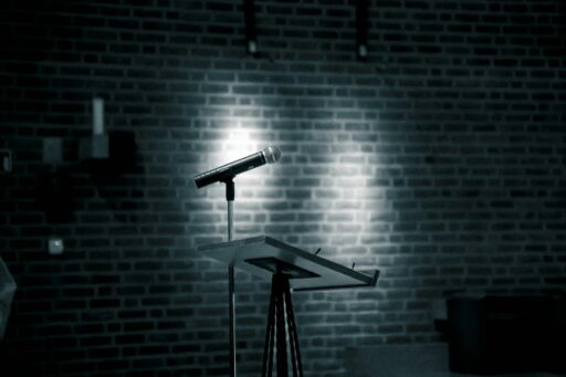 A microphone on a stand in front of a brick wall