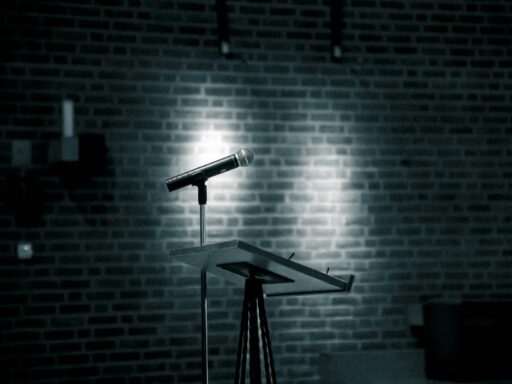 A microphone on a stand in front of a brick wall