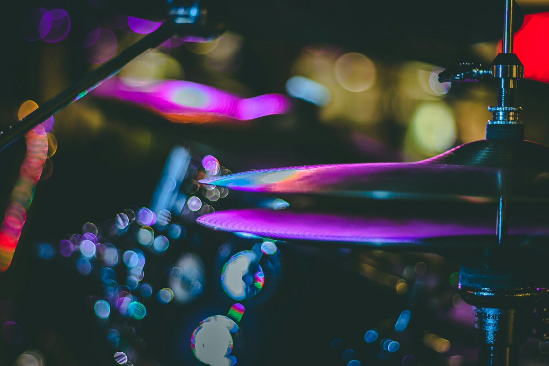 A close-up of purple-lit cymbals