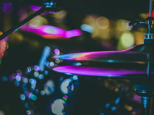 A close-up of purple-lit cymbals