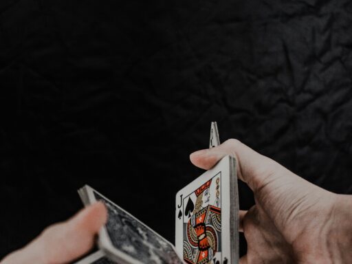 Person holding playing cards on black textile