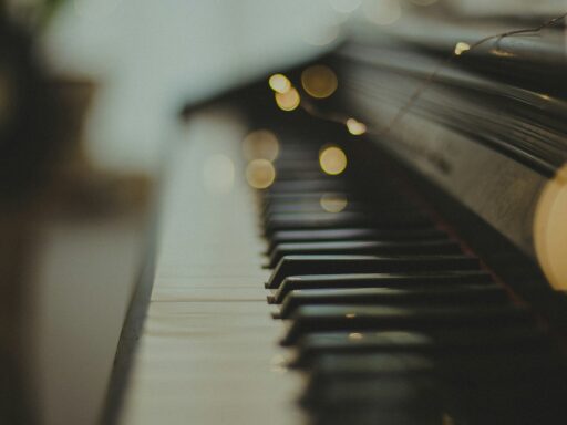 Close-up of piano keys with soft, warm lights behind them.