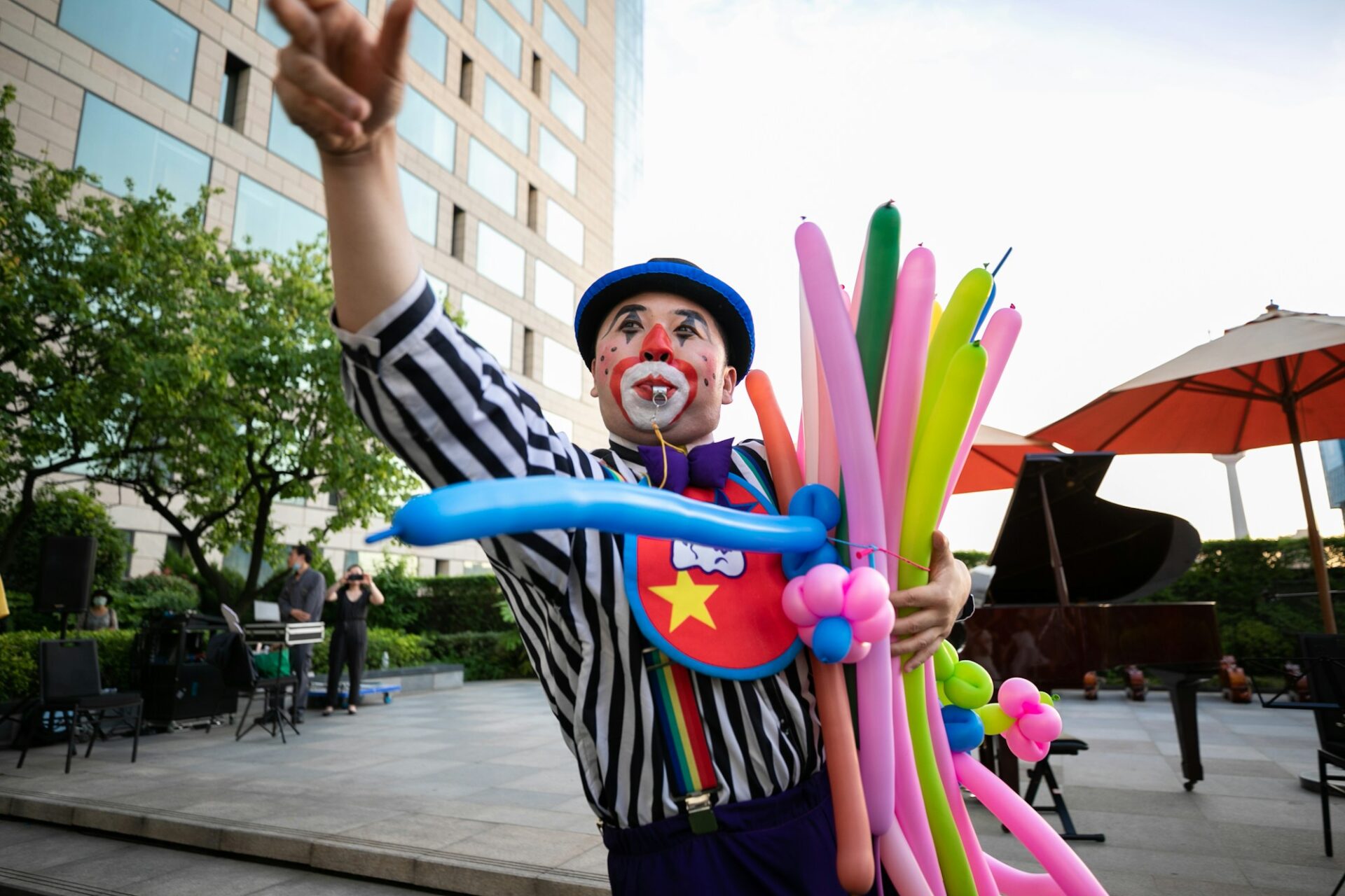 Children's party entertainer twisting balloon animals outdoors