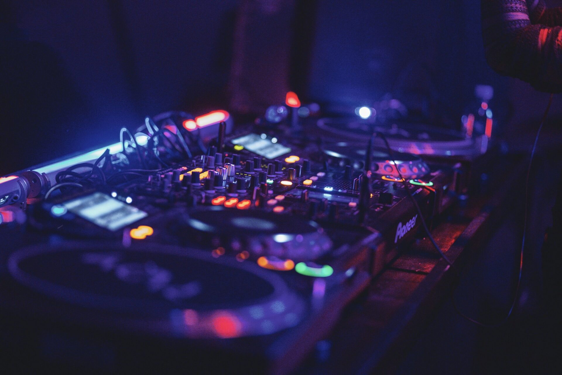 A black and blue audio mixer under colored lights