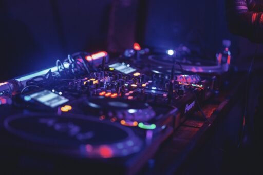 A black and blue audio mixer under colored lights