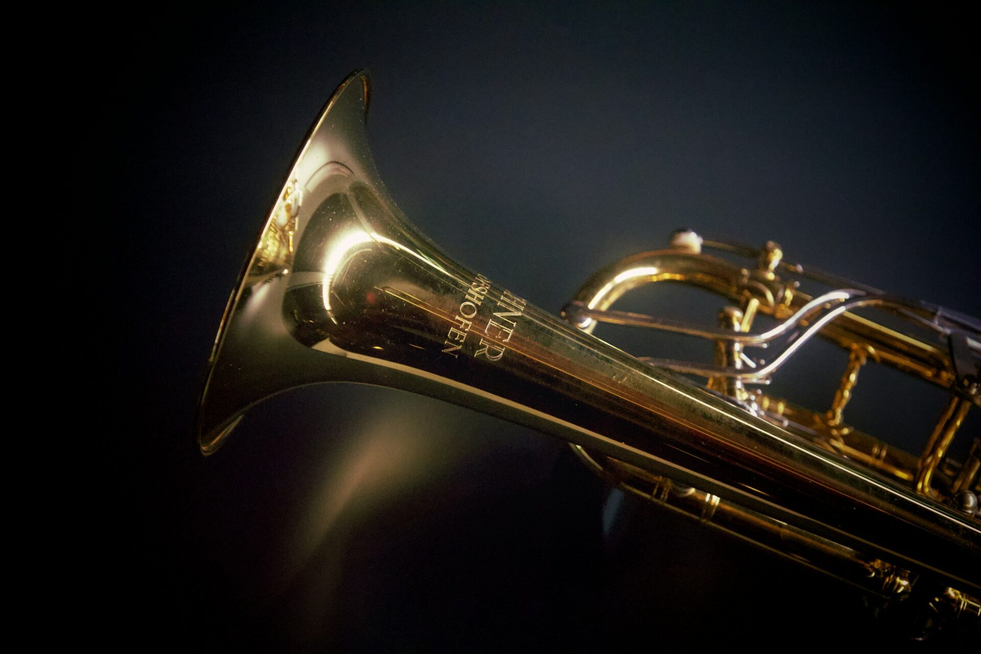 A brass trumpet against a black background