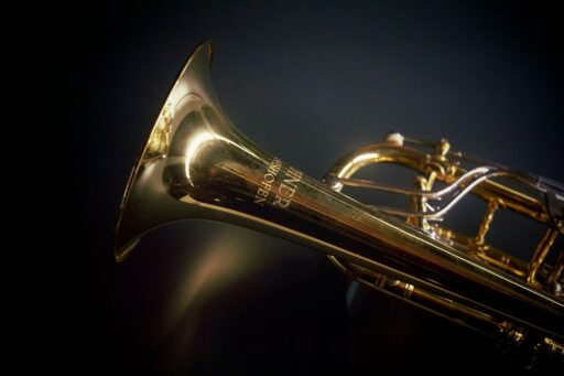 A brass trumpet against a black background