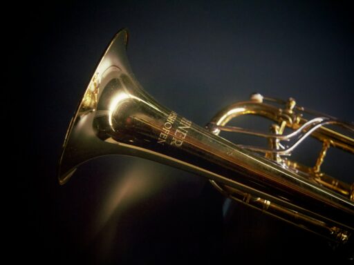 A brass trumpet against a black background