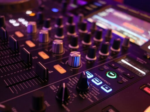 A DJ's sound board with lit-up buttons and knobs