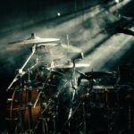 A drum set lit by warm stage lighting