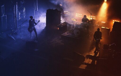 Three people playing assorted instruments on stage