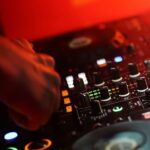 A DJ mixing a track in a dark room