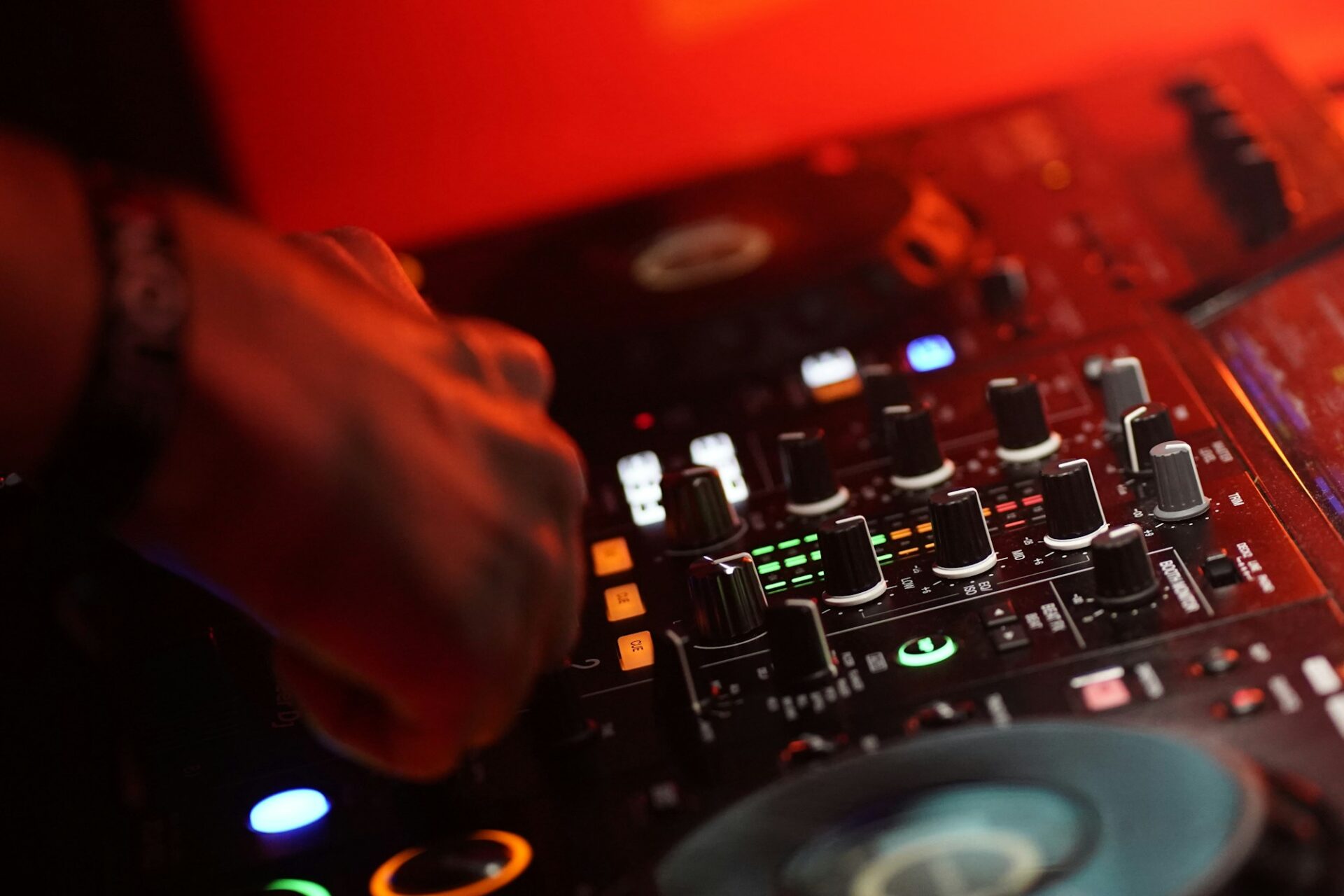 A DJ mixing a track in a dark room