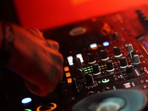 A DJ mixing a track in a dark room