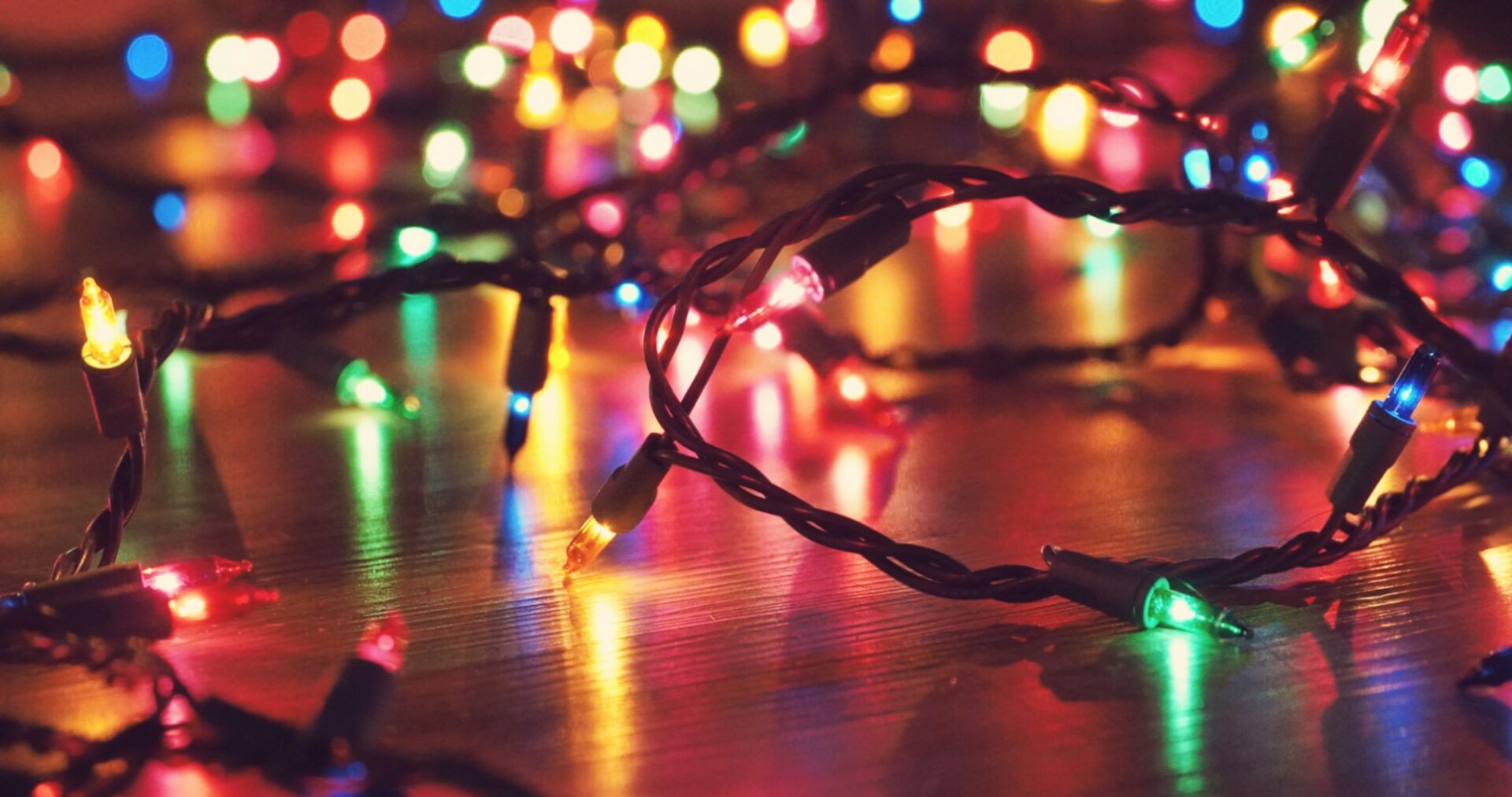 Coloured string lights glowing on a wooden floor.