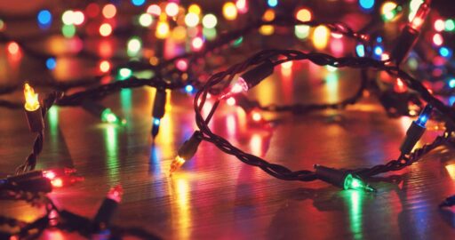 Coloured string lights glowing on a wooden floor.