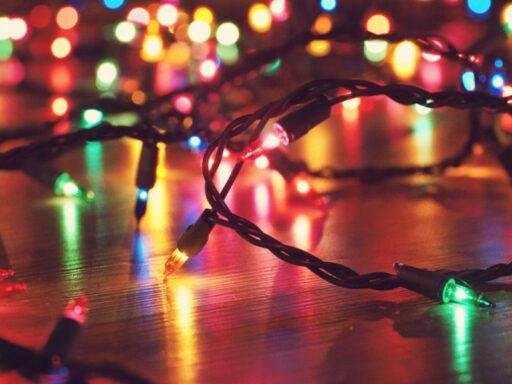 Coloured string lights glowing on a wooden floor.