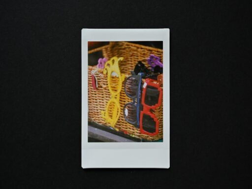 Two pairs of sunglasses in a woven basket, the kind of prop used at a photo booth