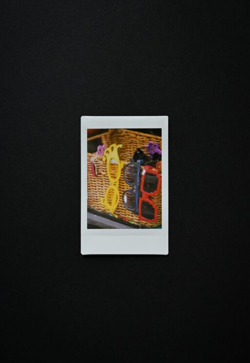 Two pairs of sunglasses in a woven basket, the kind of prop used at a photo booth